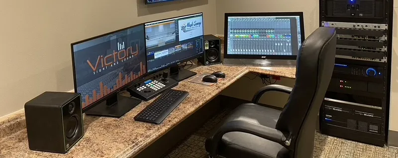 Maple Springs video-production desk with program monitors, audio-mix display, control surface, studio monitors, and the recessed equipment rack